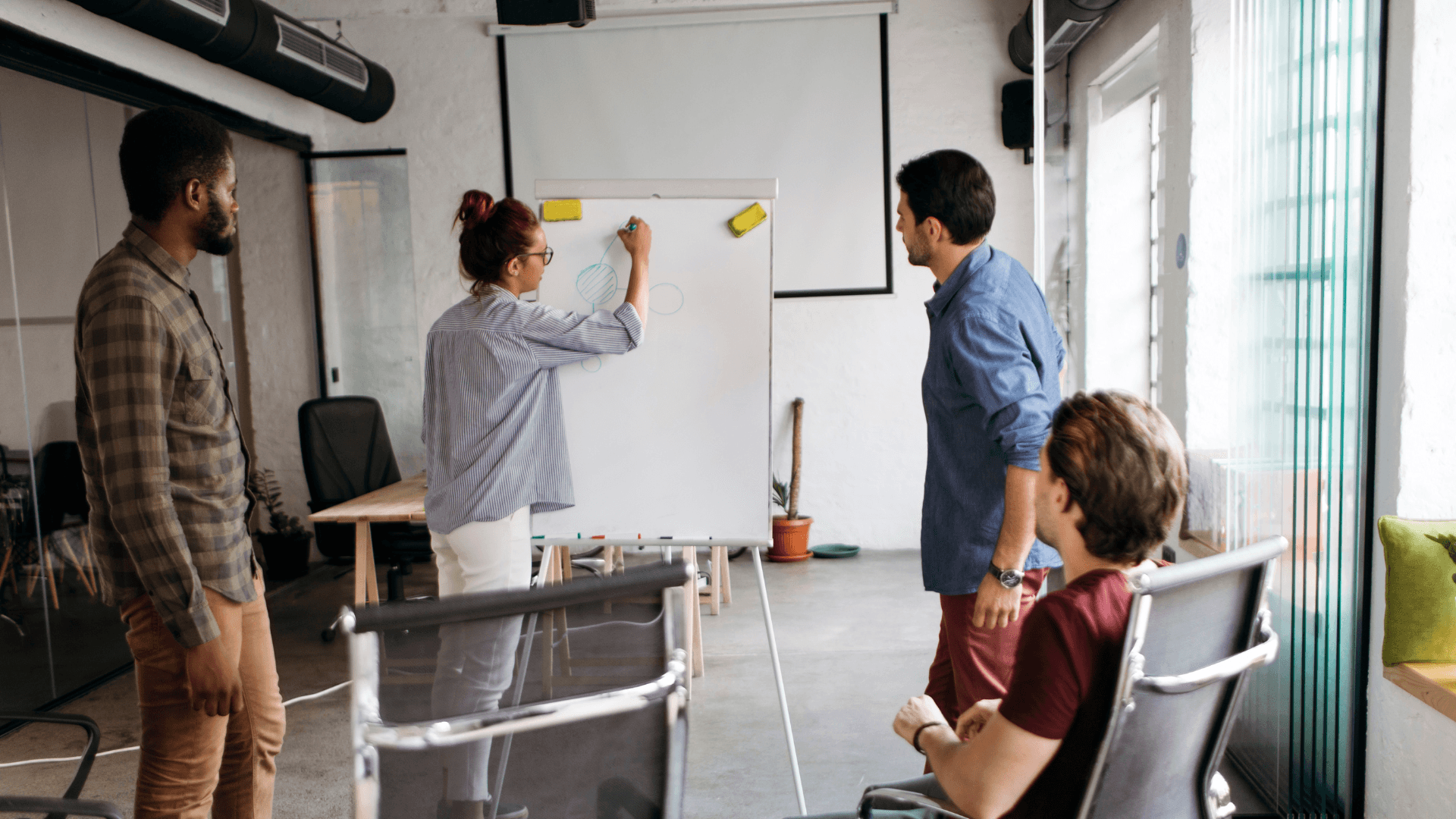 Team members collaborating at a whiteboard with colourful sticky notes