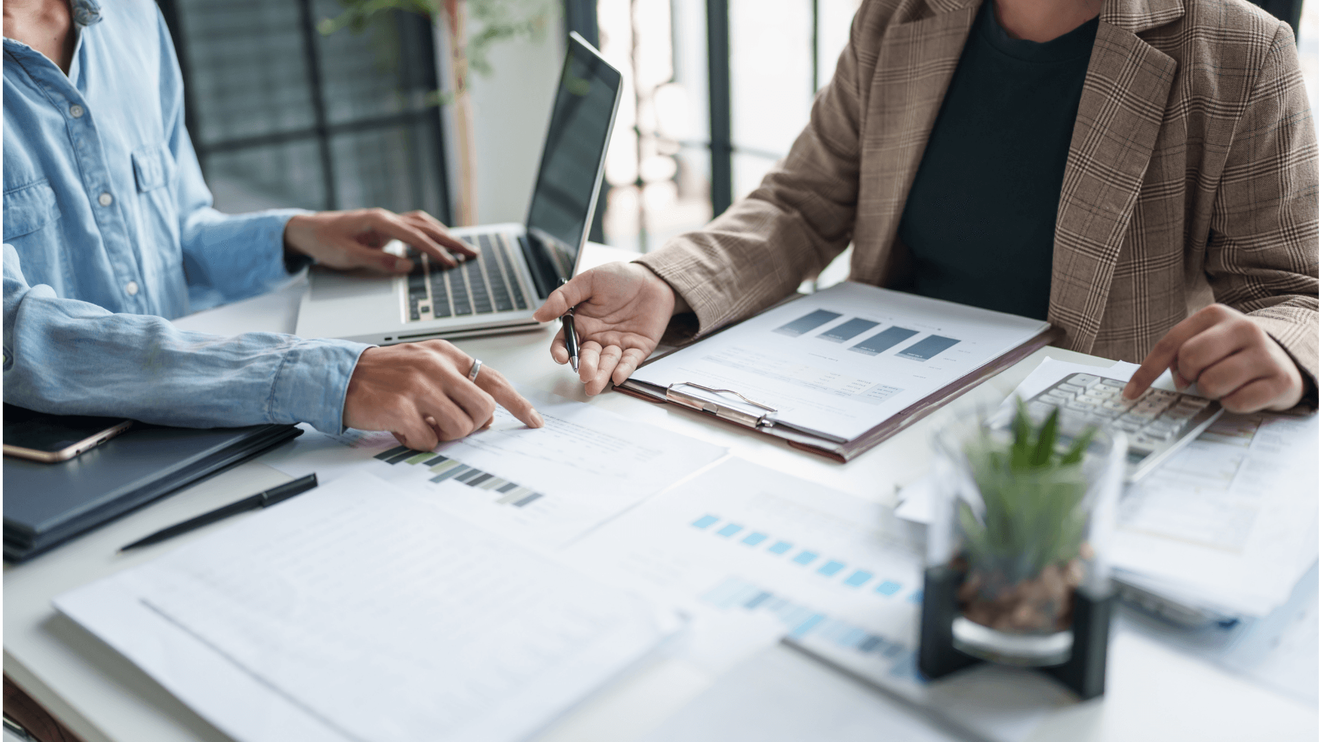 A diverse business team collaborates in front of a glass board covered in colorful sticky notes, mapping out actionable steps and priorities. This hands-on workshop environment demonstrates active problem solving and structured planning.
