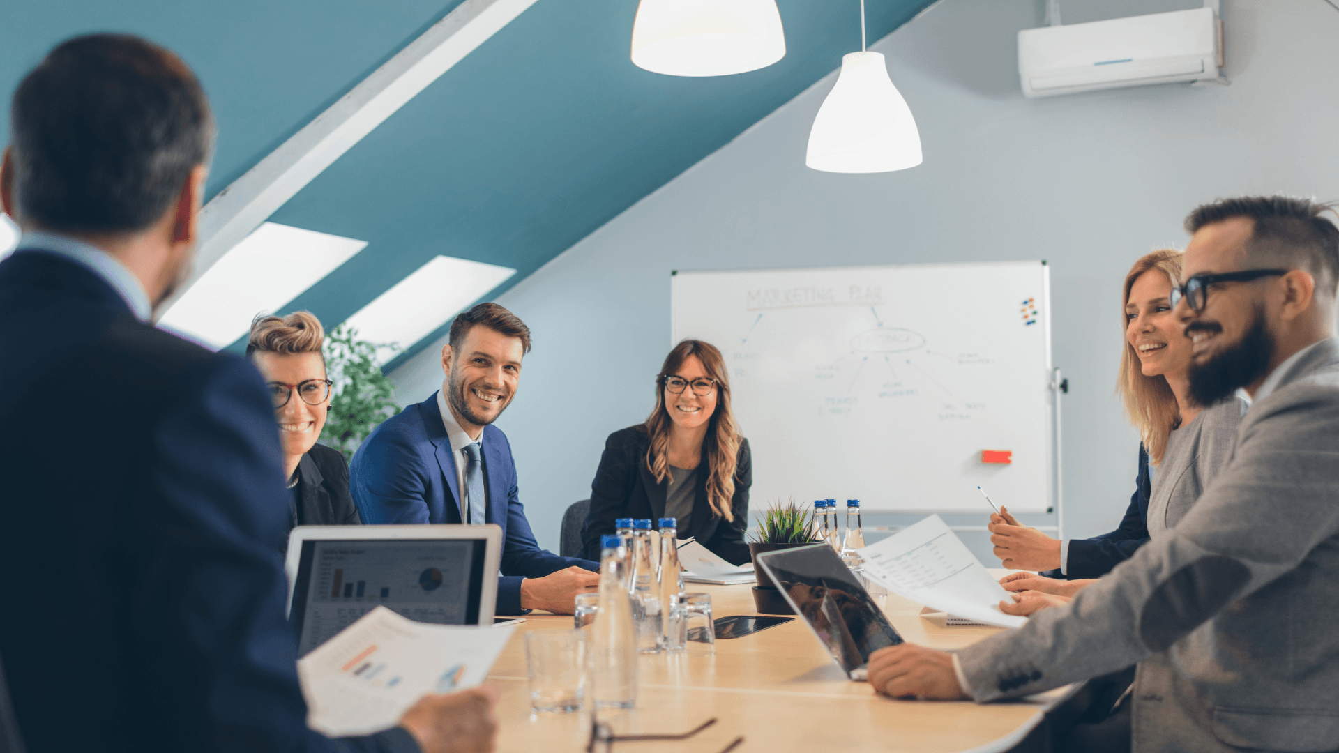 Four professionals engaged in a focused team discussion in a modern office, illustrating hands-on strategy implementation.