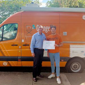 Lucas Patchett, Co-Founder and CEO of Orange Sky Australia, receives a Momentum Systems Grant from Greg Gunther, Director and Co-Founder of Your Business Momentum.